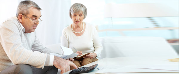 Un couple d’aînés canadiens utilisant la calculatrice d’hypothèque inversée pour calculer le montant du prêt qu’ils recevront en fonction de la valeur nette de leur résidence.