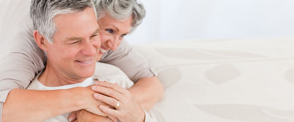 Couple d’aînés s’enlaçant et souriant alors qu’on répond à leurs questions sur les hypothèques inversées de la Banque HomeEquity, Canada.